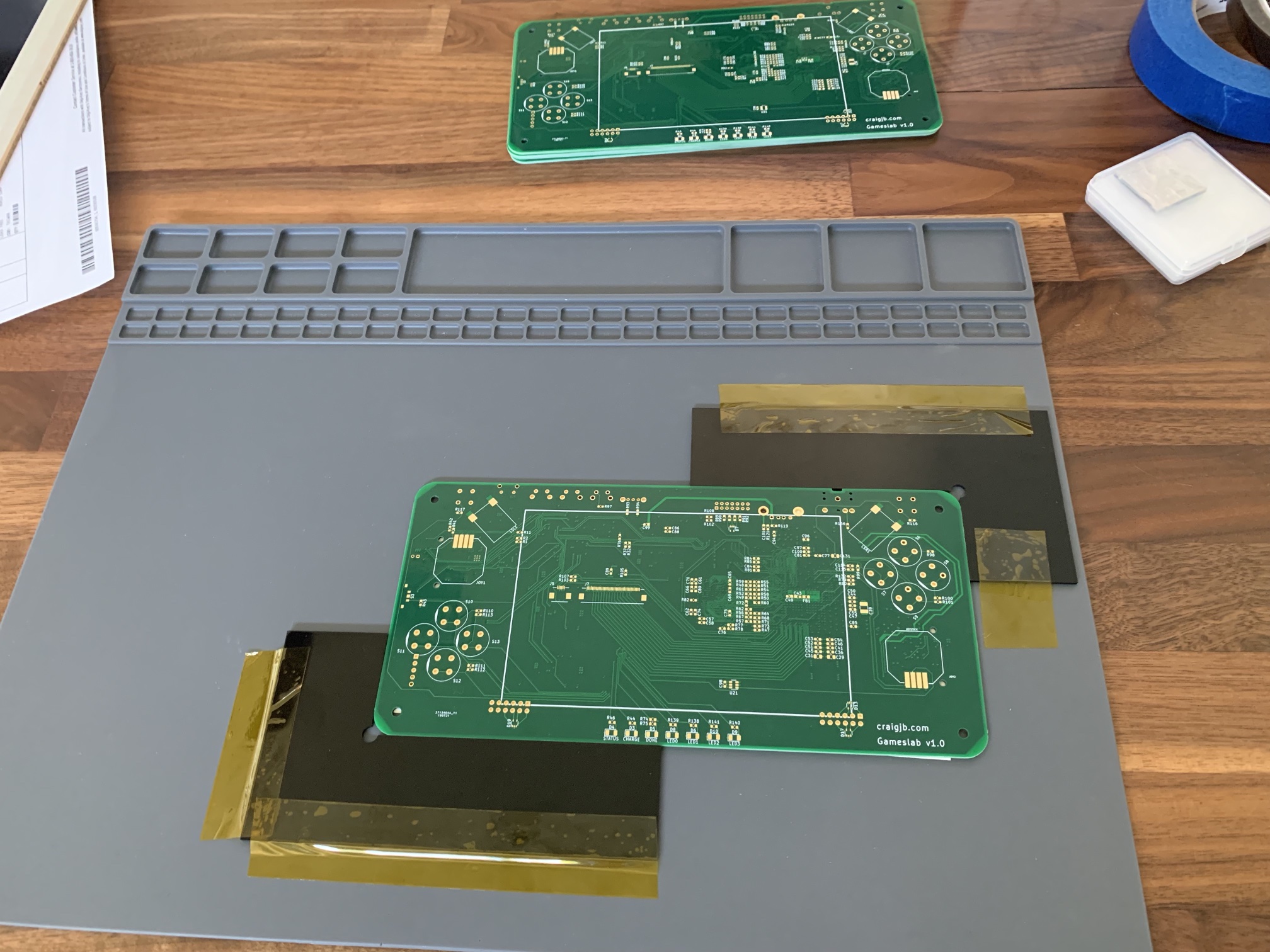 Taping the PCB in place before stenciling